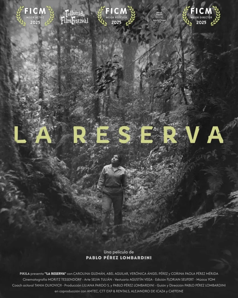 Póster de La Reserva, en blanco y negro: una mujer camina por un bosque frondoso mirando hacia arriba.
